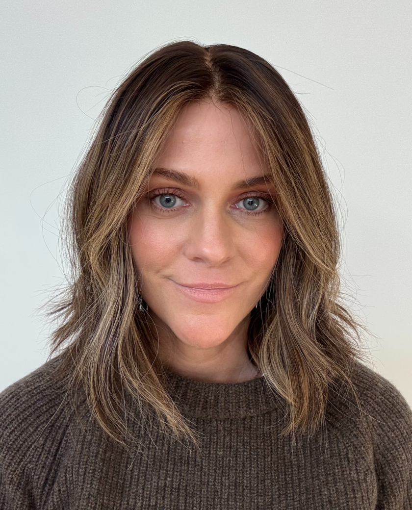 Kit — Neutral dark brown base with sandy blonde highlights throughout, along with champagne money pieces.